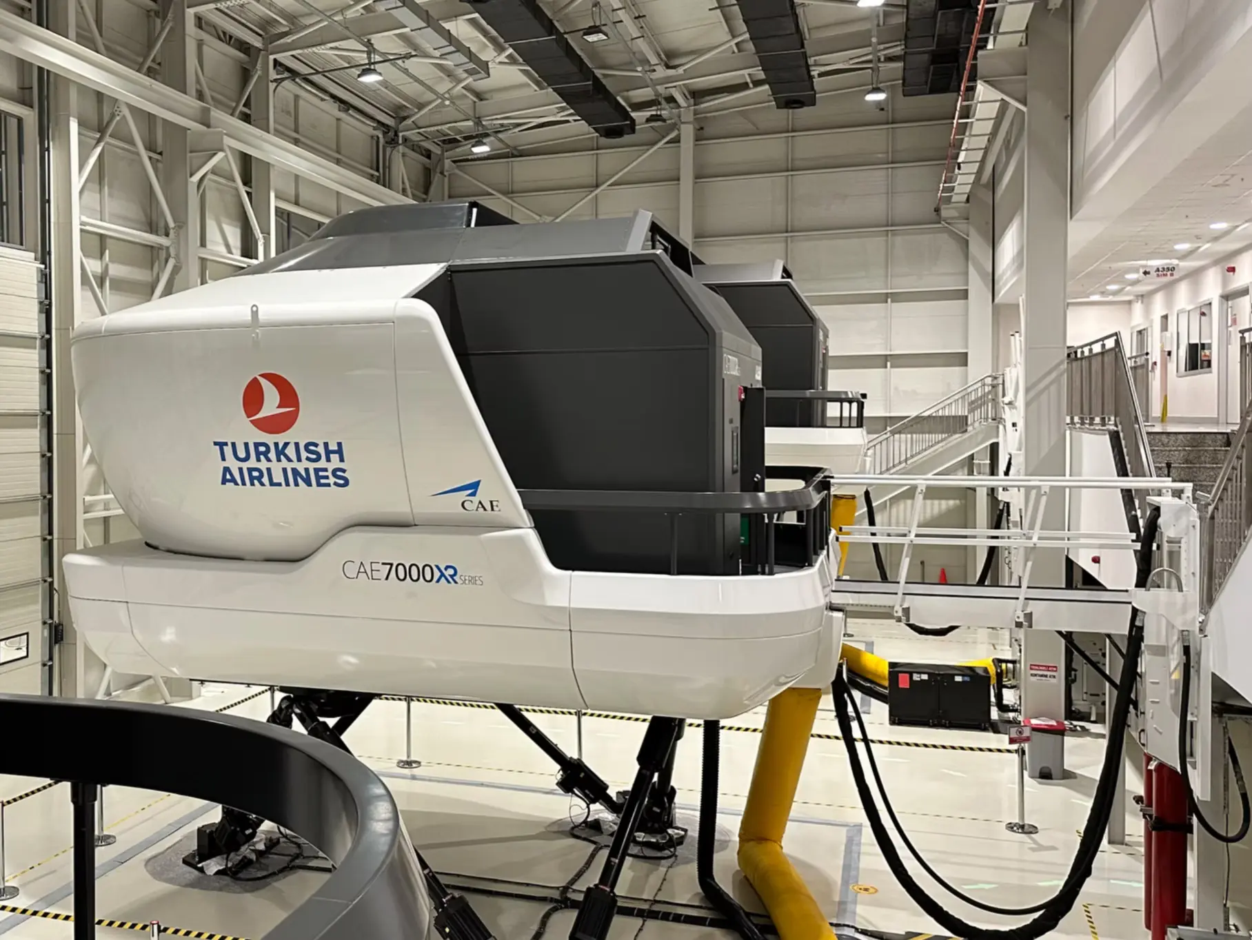 A Turkish Airlines full flight simulator inside a modern aviation training hall